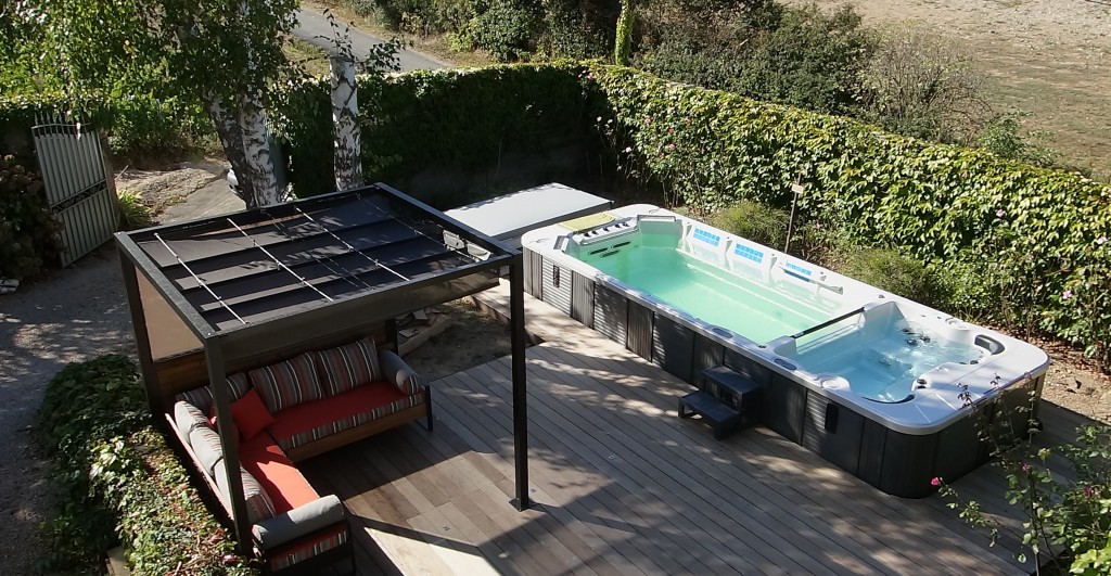  Aménagement de terrasse avec pergola, canapé, sol ipé et spa : un espace de détente aussi convivial que confortable