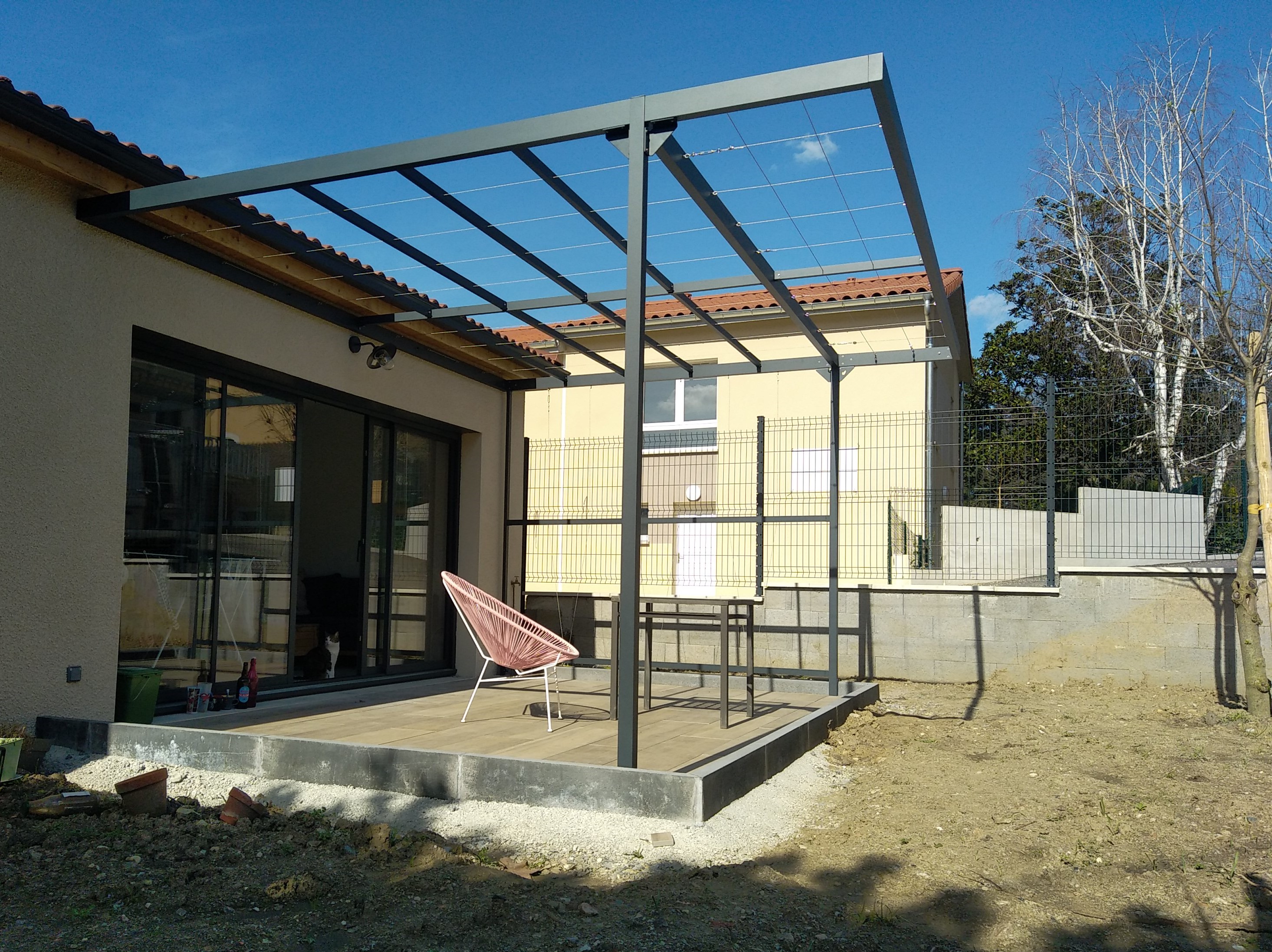 Pour ombrager la terrasse de cette maison neuve, la pergola végétale sur mesure va guider les végétaux grimpants pour faire un ombrage agréable et isoler des vis à vis.